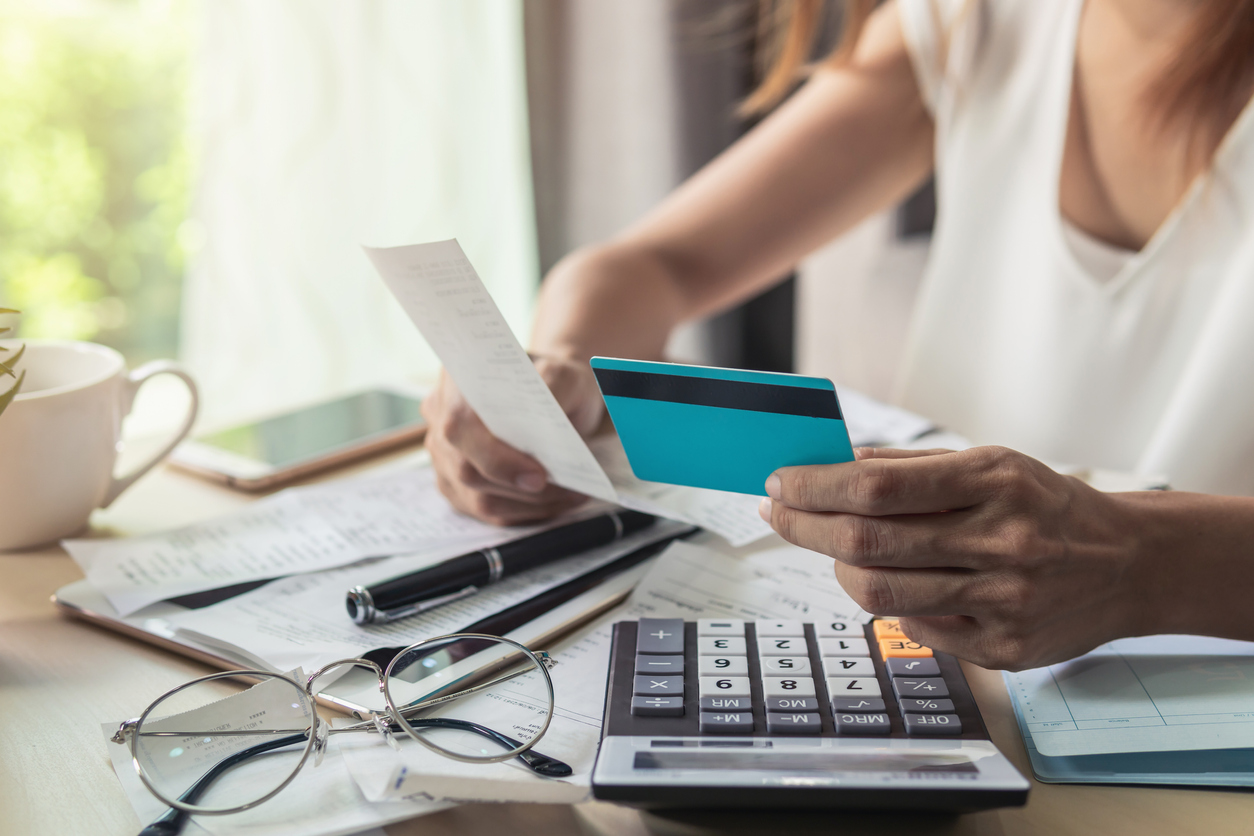 A person looking over a receipt, balancing their personal finances