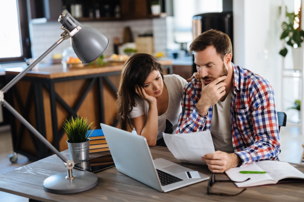 Stressed couple reviewing their finances.