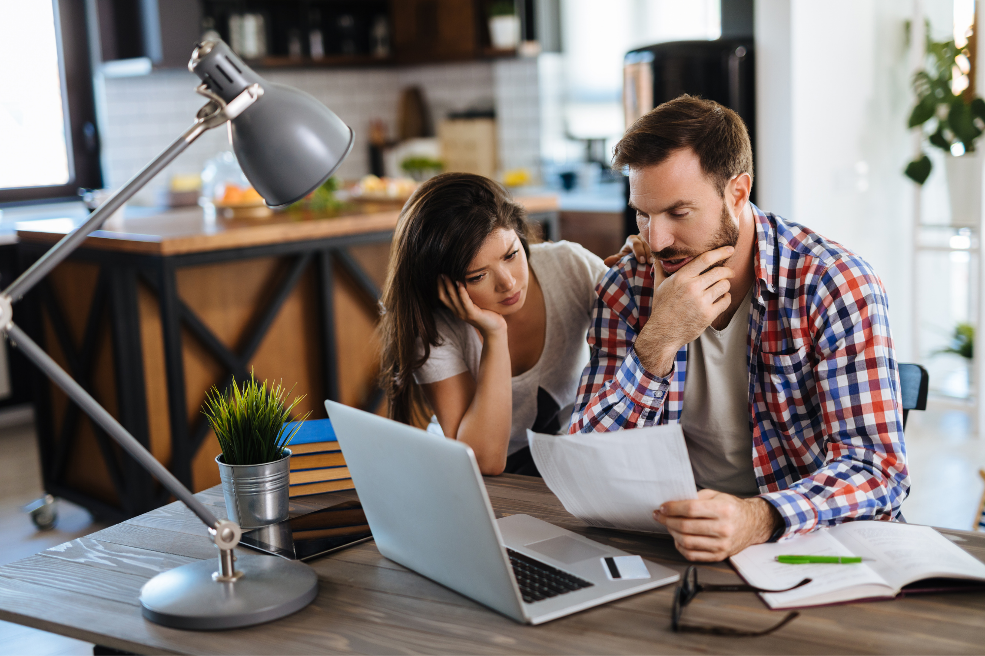 Stressed couple reviewing their finances.